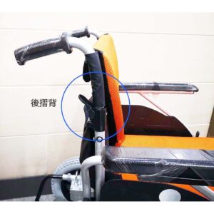 Wheelchair King Une vue rapprochée du fauteuil roulant électrique orange et noir de la marque taïwanaise Merits WP902, mettant en évidence le mécanisme spécifique situé à l'arrière. Un cercle bleu marque l'entité, avec un texte japonais pointant vers elle.