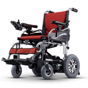 La silla de ruedas eléctrica roja y negra de la marca taiwanesa KARMA KP-25.2 tiene una rueda trasera grande, una rueda delantera pequeña y un panel de control de brazo en el reposabrazos izquierdo.