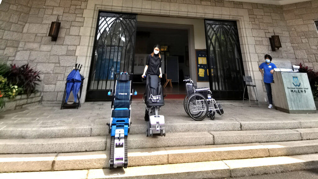 車椅子の王様は建物の入り口前に一人で立っており、階段昇降用の車椅子や普通の車椅子などの福祉用具を展示していました。近くにはもう一人の人がいました。
