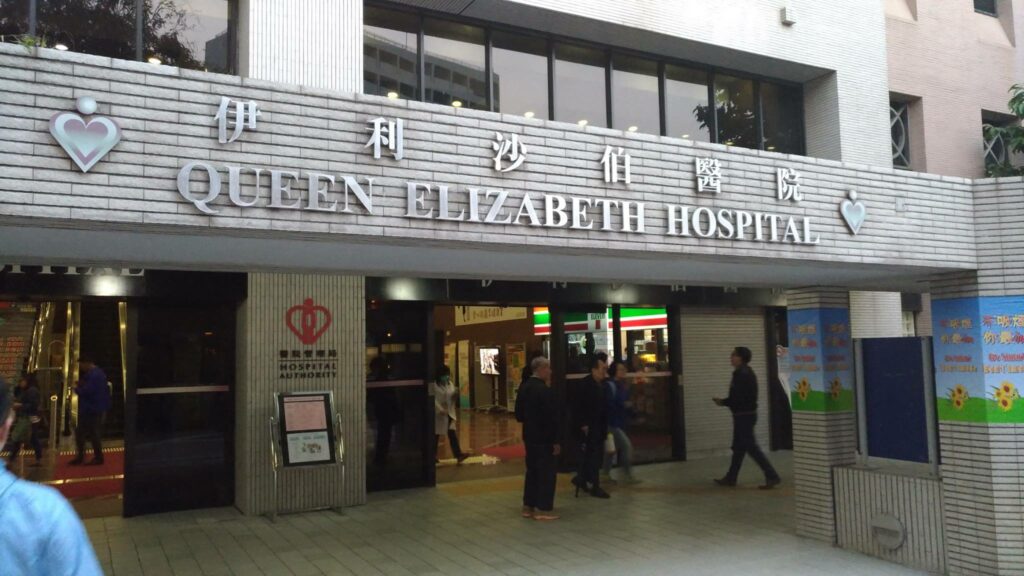 輪椅王 伊莉莎白女王醫院入口處，有人進出，設有中英文雙語標誌。