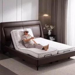 一名男子坐在醫療床/護理床功能簡介上，床上放著德國品牌 1.8m 床寬獨立床墊電動床護理無線遙控 WC820（出口版）。