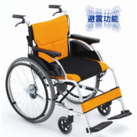 【輪椅王】 手動輪椅,配有橙色和黑色軟墊座椅和靠背、大後輪和較小前輪,專為行動輔助而設計。背景中有亞洲人物。此型號為日本品牌Miki FR43JD-22手推輪椅(環抱煞車)。