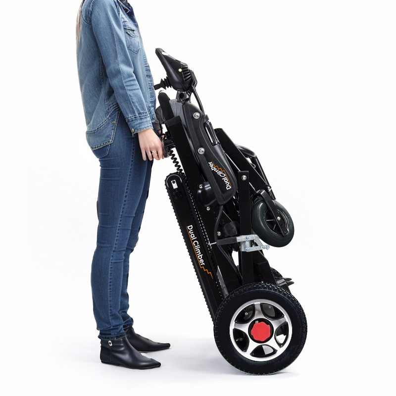 【車椅子王】スタイリッシュな黒色のデザインと車輪を採用した直立型電動階段昇降車デュアルクライマー【2in1車椅子階段機】の隣に人が立っています。誰の顔も見えない。